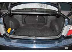 Багажник очень вместительный – 520 л, а еще его можно увеличить, сложив заднее сиденье. С левой стороны упрятан CD-чейнджер фирменной аудиосистемы. 