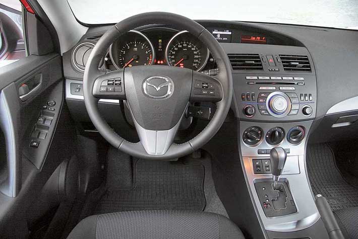 Торпедо Mazda3 отличается наибольшим количеством кнопок. Немного несуразно смотрятся  дисплеи торпедо : все они с абсолютно разным дизайном и типом шрифтов. Некуда и флешку подключить, есть лишь разъем AUX. Зато только в этой машине руль обтянут кожей. 