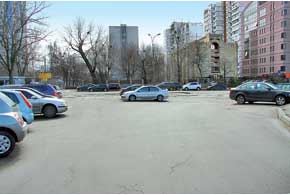 Неправильная парковка на перекрестке ул. Оранжерейной и Дегтяревской. Стоящие посередине авто мешают движению транспорта. Сужают проезд и машины, стоящие вдоль бордюра.