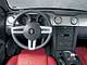 Ford Mustang GT. Салон по стильности решений не уступает внешности: трехспицевый руль, комбинация приборов а-ля 60-е, красная обшивка.